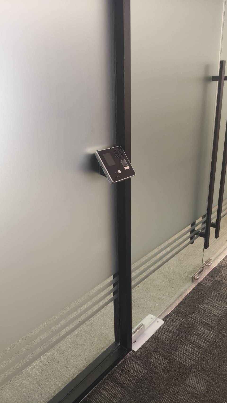 ZKTeco device installed on glass door frame at Jack Com Office